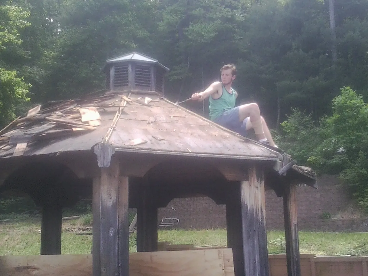 Tearing the old roof off a wooden gazebo before new shakes in Winchester